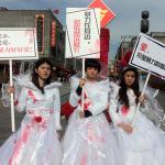 color photograph of Chinese activists wearing bloodied wedding gowns to protest domestic violence