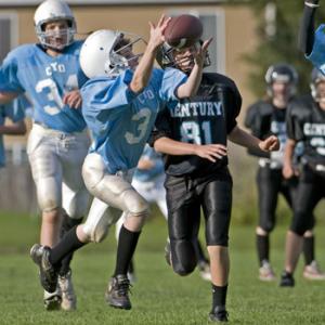 young boys playing football in uniform