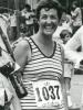 black and white photo of Joan Schafer wearing a tank top and runner's number for a race