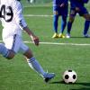 photograph of a person kicking a soccer ball