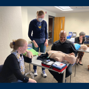 Sarah Ellerholz, Allison Alexy, and Terrence Crimes practice using an AED on a mannequin