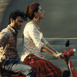 A photo of a man and woman riding on a scooter