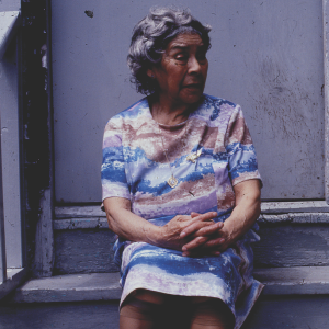 color photo of elderly Latina grandmother sitting on a front stoop, 1970s