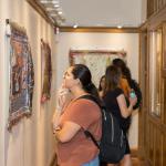 A student looks closely at a digital print on canvas in the Lane Hall exhibit space
