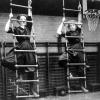 Historical photo of two women climbing rope ladders circa 1910